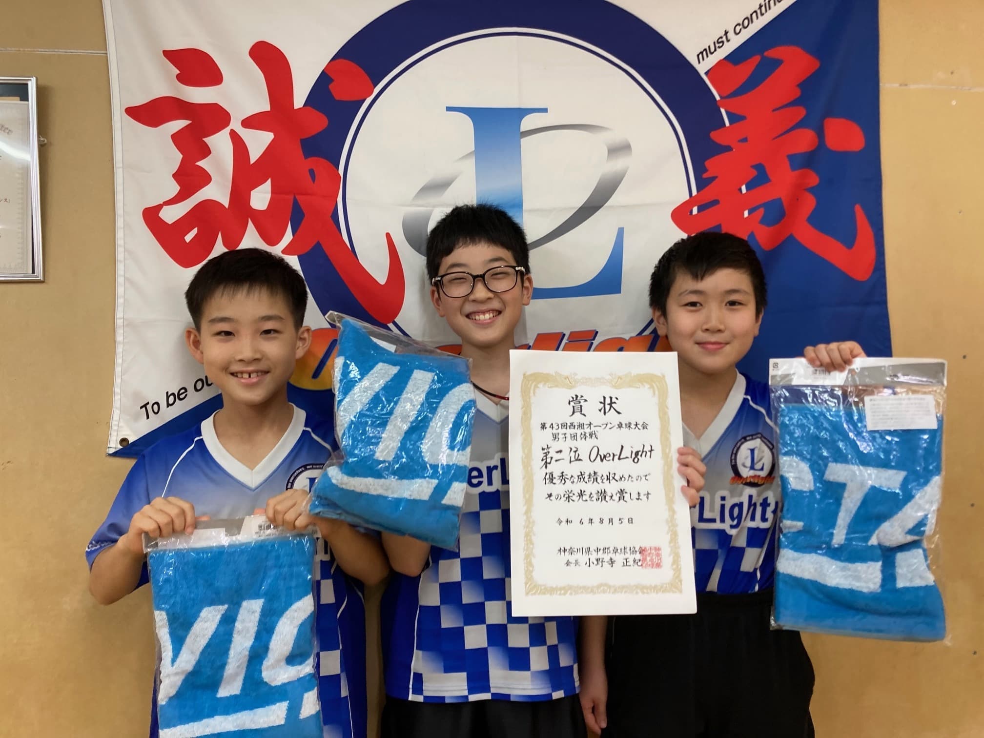 五反田・品川の卓球スクールOverLight卓球道場のジュニアチームの子どもたちが第43回西湘オープン卓球大会で第二位の賞状と記念タオルを持って笑顔で記念撮影